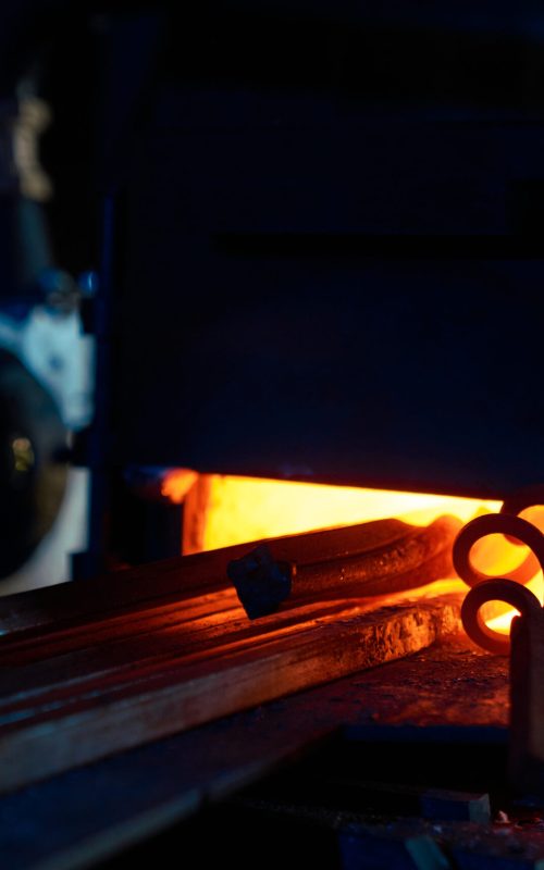 Close up of various pieces of iron heating inside forge furnace. Burning fire with steel. Preparation of metal for processing.
